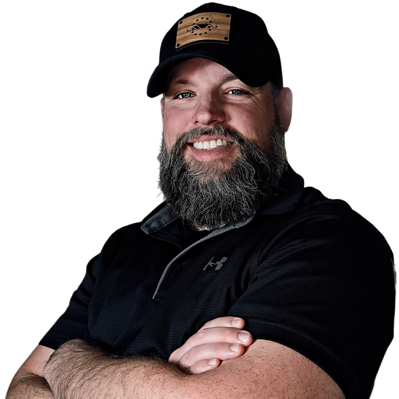 Toby Russell wearing a black cap and quarter-zip, with his arms crossed
